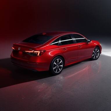 2027 Honda Civic Sedan Sport Touring Hybrid in Rallye Red rear three-quarter view in a studio (Compact Sedan)