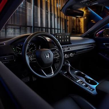 2027 Honda Civic Sedan Sport Touring Hybrid dashboard and center console view at night (Compact Sedan)